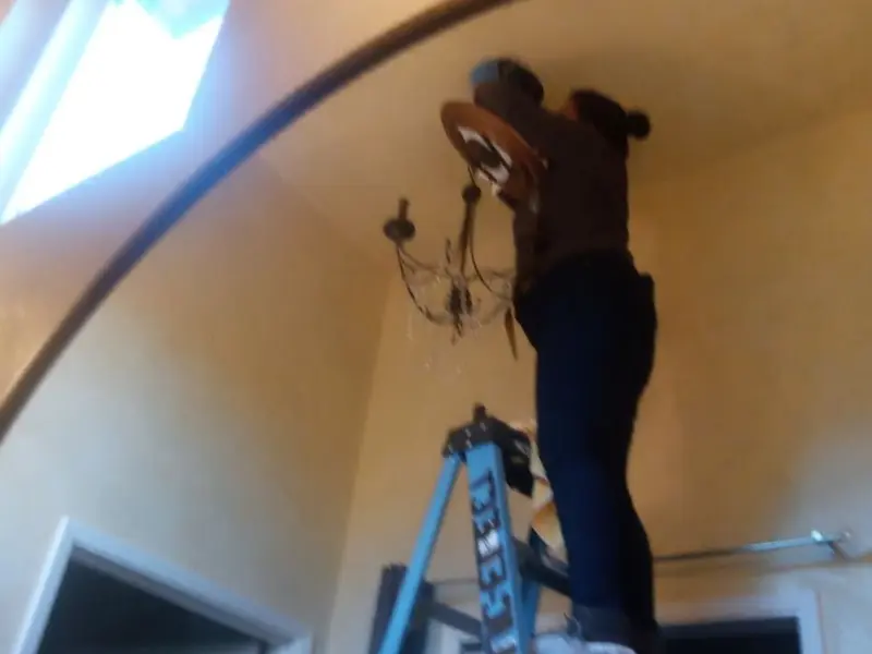 Electrician installing a chandelier in a Hapeville residence